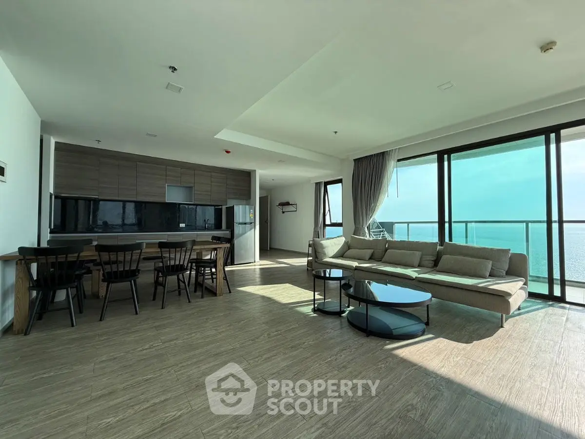 Luxurious open-plan living room with ocean view and modern kitchen.