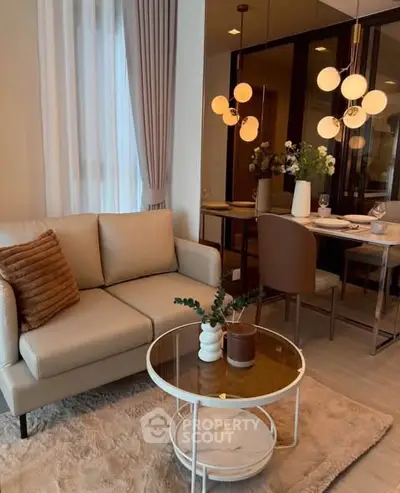Stylish living room with modern decor, cozy sofa, elegant dining area, and chic lighting fixtures.