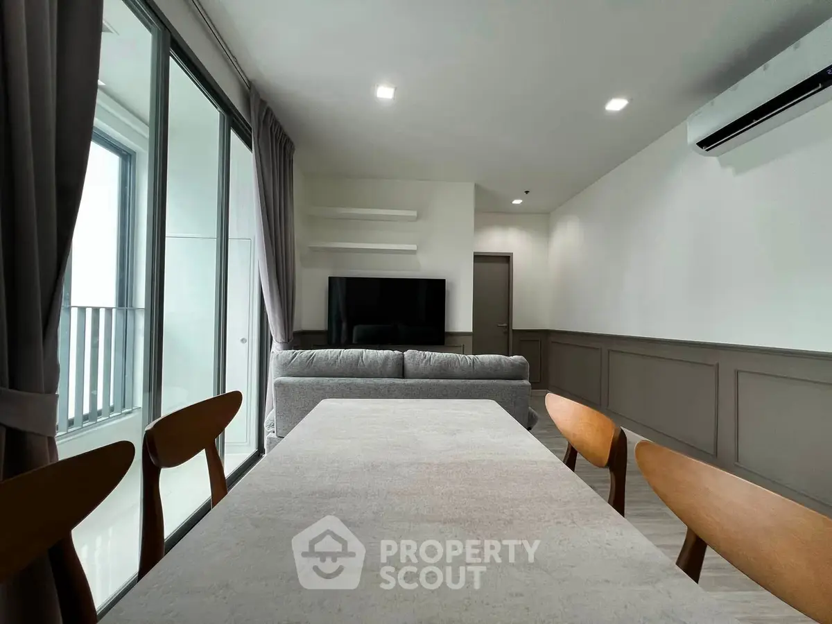 Modern living room with sleek furniture and large windows offering natural light.