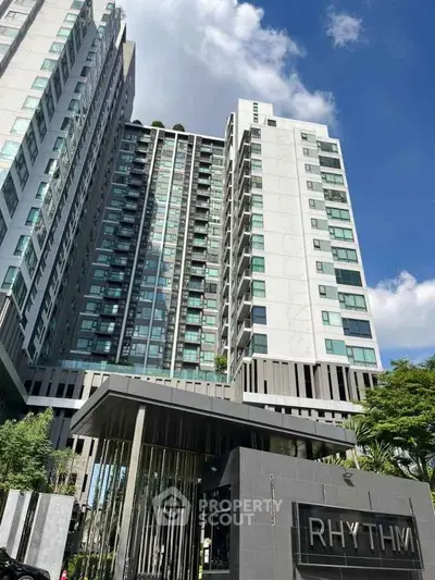 Modern high-rise condominium with sleek architecture and lush greenery.