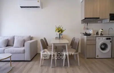 Modern living room with dining area and kitchen featuring washing machine and air conditioning.