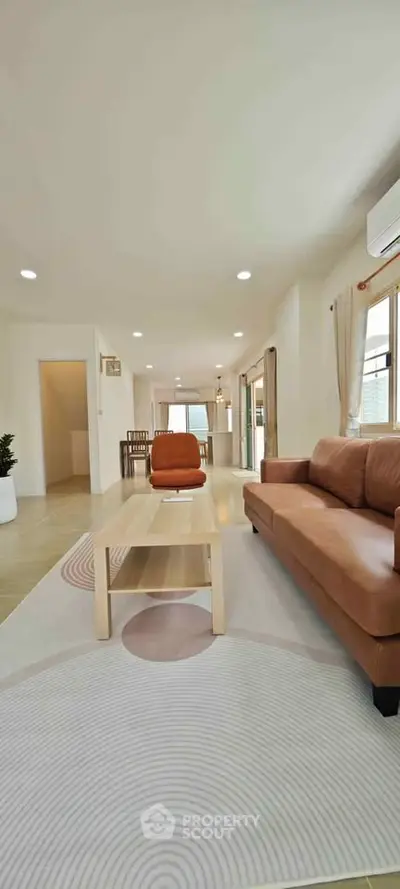 Spacious modern living room with stylish furniture and natural light, perfect for relaxation and entertaining.