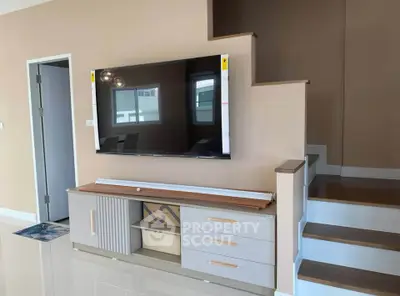 Modern living room with wall-mounted TV and stylish staircase
