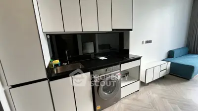 Modern compact kitchen with integrated washing machine and sleek cabinetry