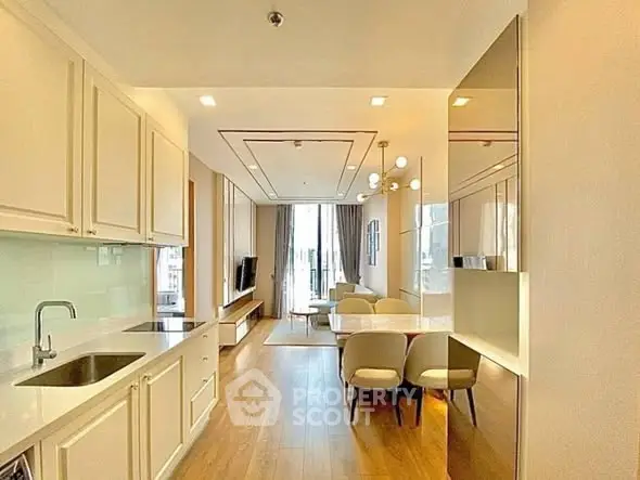 Elegant open-layout kitchen and living room with modern decor and natural light.