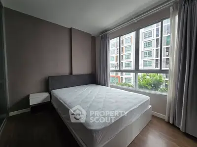 Modern bedroom with large window and city view in a stylish apartment