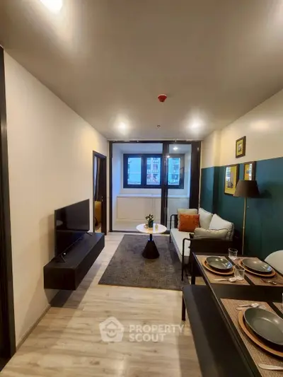 Modern living room with stylish decor and dining area, featuring a wall-mounted TV and cozy seating.