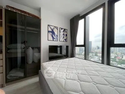 Modern bedroom with large windows offering stunning city views, featuring sleek decor and ample natural light.