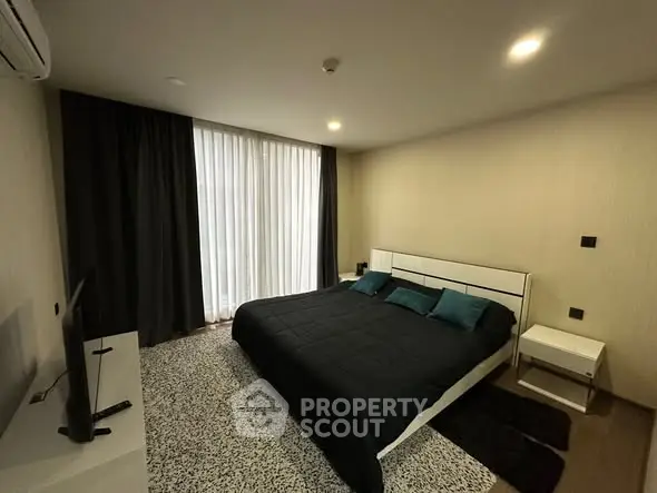 Modern bedroom with sleek design, featuring a comfortable bed, stylish decor, and ample natural light.
