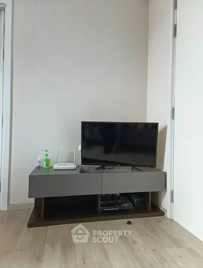 Modern living room corner with TV and stylish console on wooden floor