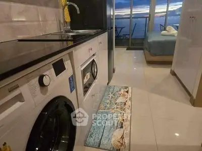 Chic apartment with ocean view, modern kitchen, and cozy bedroom.