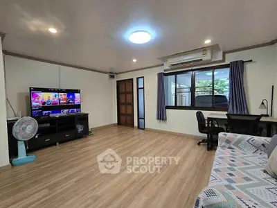 Spacious living room with modern decor and large window, perfect for relaxation and entertainment.