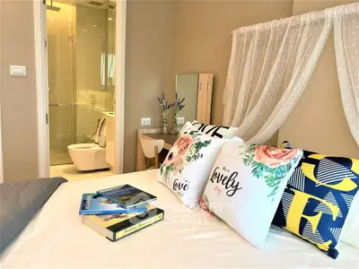 Charming bedroom with elegant decor and ensuite bathroom, featuring cozy pillows and stylish furnishings.