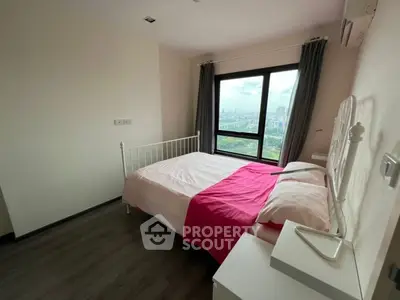 Modern bedroom with city view, featuring a cozy bed and large window for natural light.