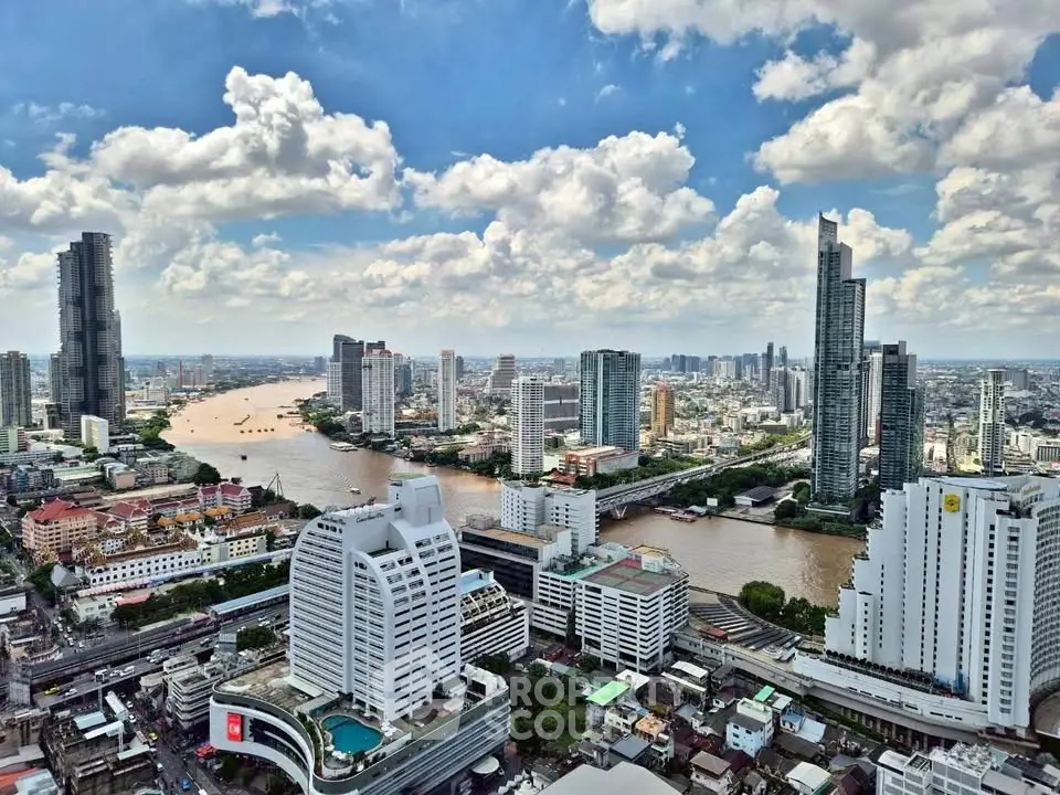 Stunning cityscape view showcasing modern skyscrapers and a winding river under a vibrant blue sky.