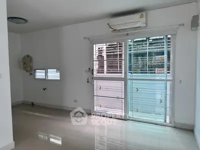 Spacious unfurnished room with large windows and air conditioning, perfect for customization.