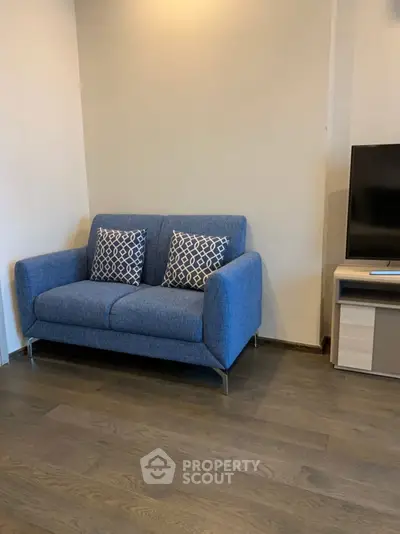 Cozy living room with modern blue sofa and flat-screen TV