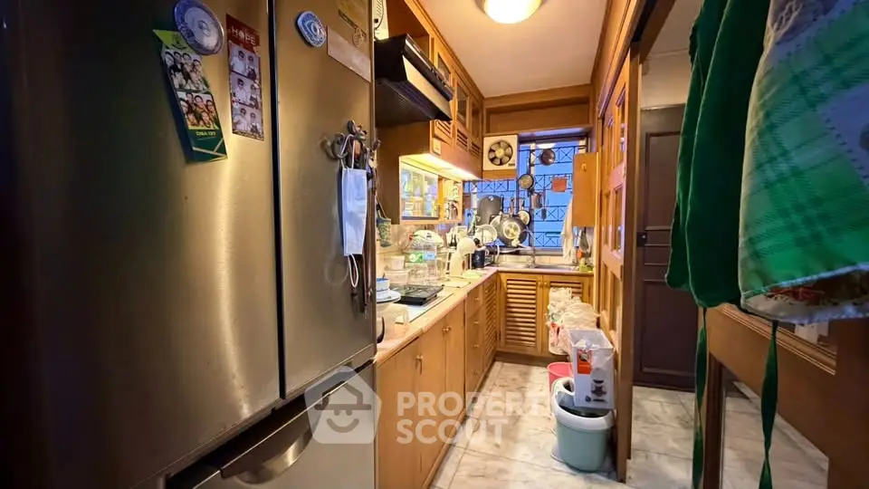 Cozy kitchen with wooden cabinets and modern appliances in a compact layout.