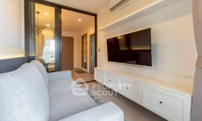 Modern living room with sleek TV setup and cozy gray sofa in stylish apartment.