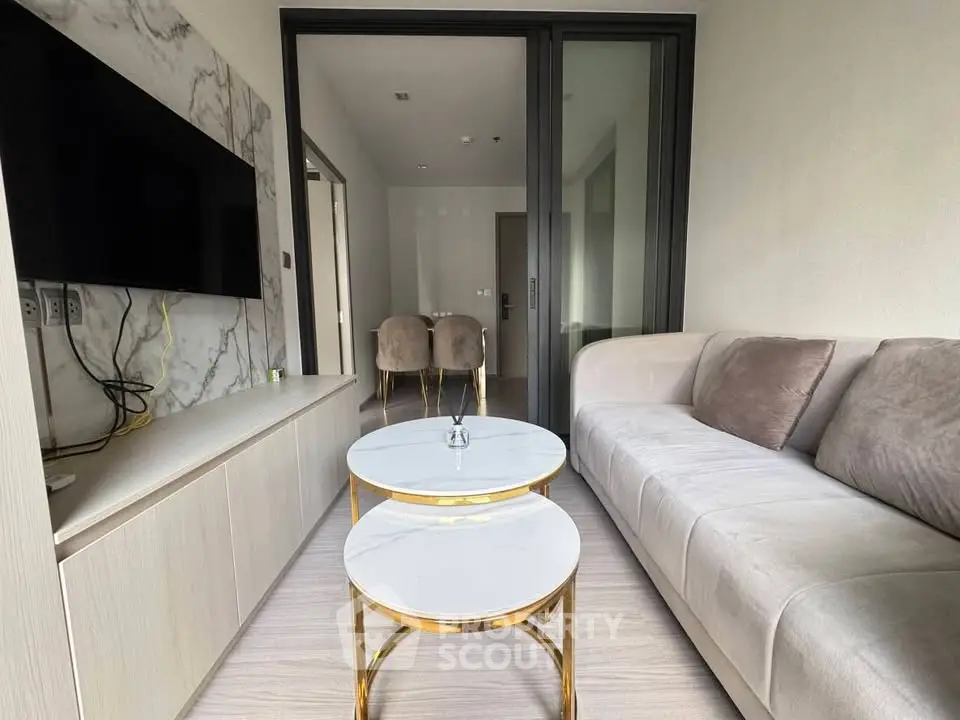 Modern living room with elegant marble accents and plush seating in a stylish apartment.
