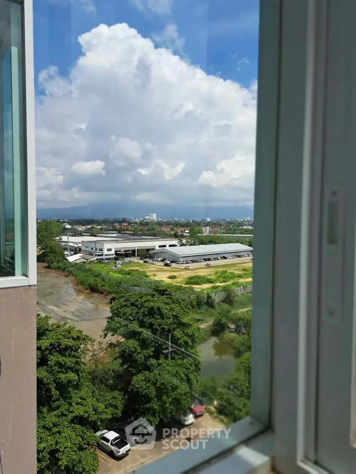 Stunning cityscape view from a high-rise window, showcasing lush greenery and urban landscape.