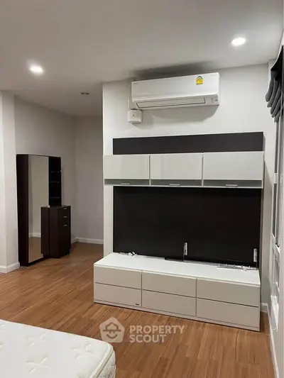 Modern bedroom with sleek furniture and hardwood flooring