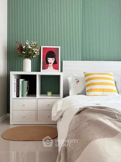 Stylish bedroom with modern decor and vibrant green accent wall.