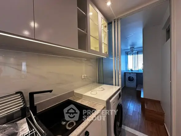 Modern kitchen with sleek cabinetry and integrated washing machine