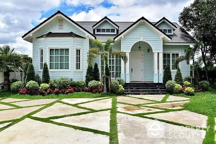 Charming single-story house with manicured garden and unique geometric driveway design.