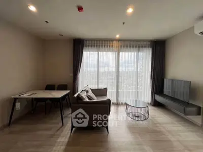 Modern living room with large windows and stylish furniture, offering a bright and inviting atmosphere.