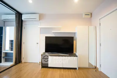 Modern living room with sleek TV stand and mirrored closet doors