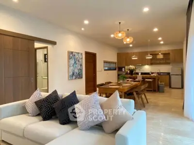 Spacious open-plan living room and kitchen with modern decor and elegant lighting.