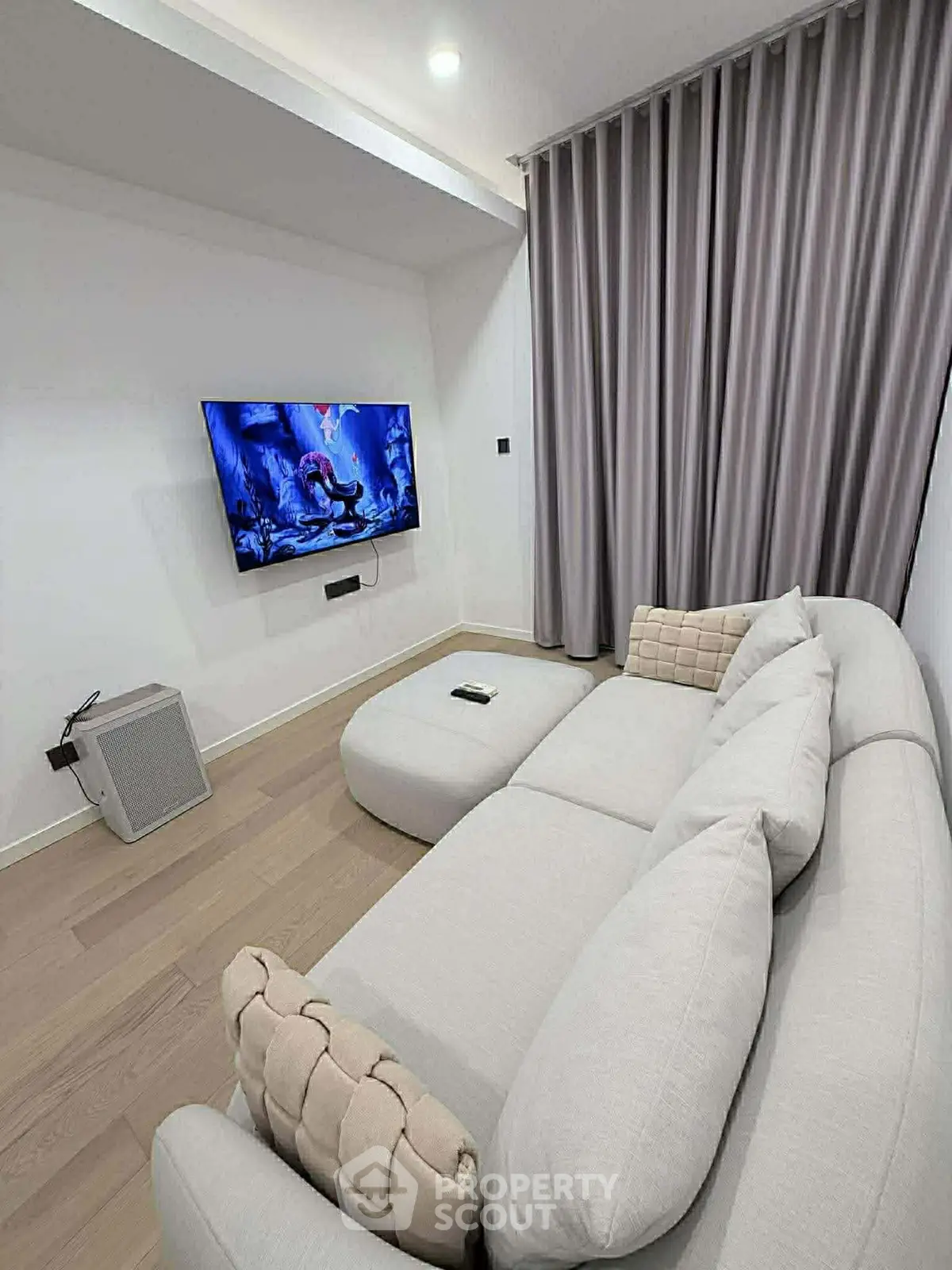Modern living room with cozy sectional sofa and wall-mounted TV, perfect for relaxation.