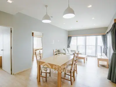 Spacious modern living room with natural light and elegant wooden furniture.