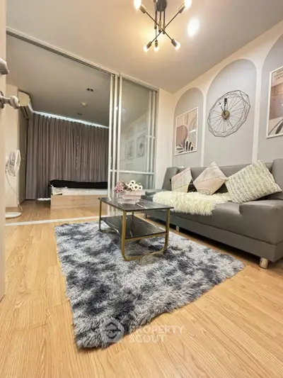 Stylish living room with modern decor and cozy ambiance, featuring plush rug and elegant lighting.
