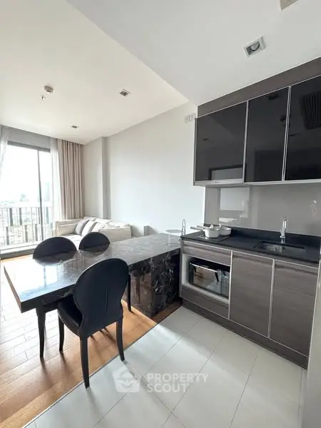 Modern open-layout kitchen with dining area and city view, featuring sleek cabinetry and contemporary furnishings.