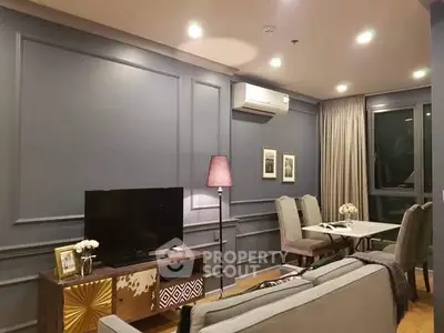Elegant living room with modern decor and dining area, featuring stylish lighting and cozy ambiance.