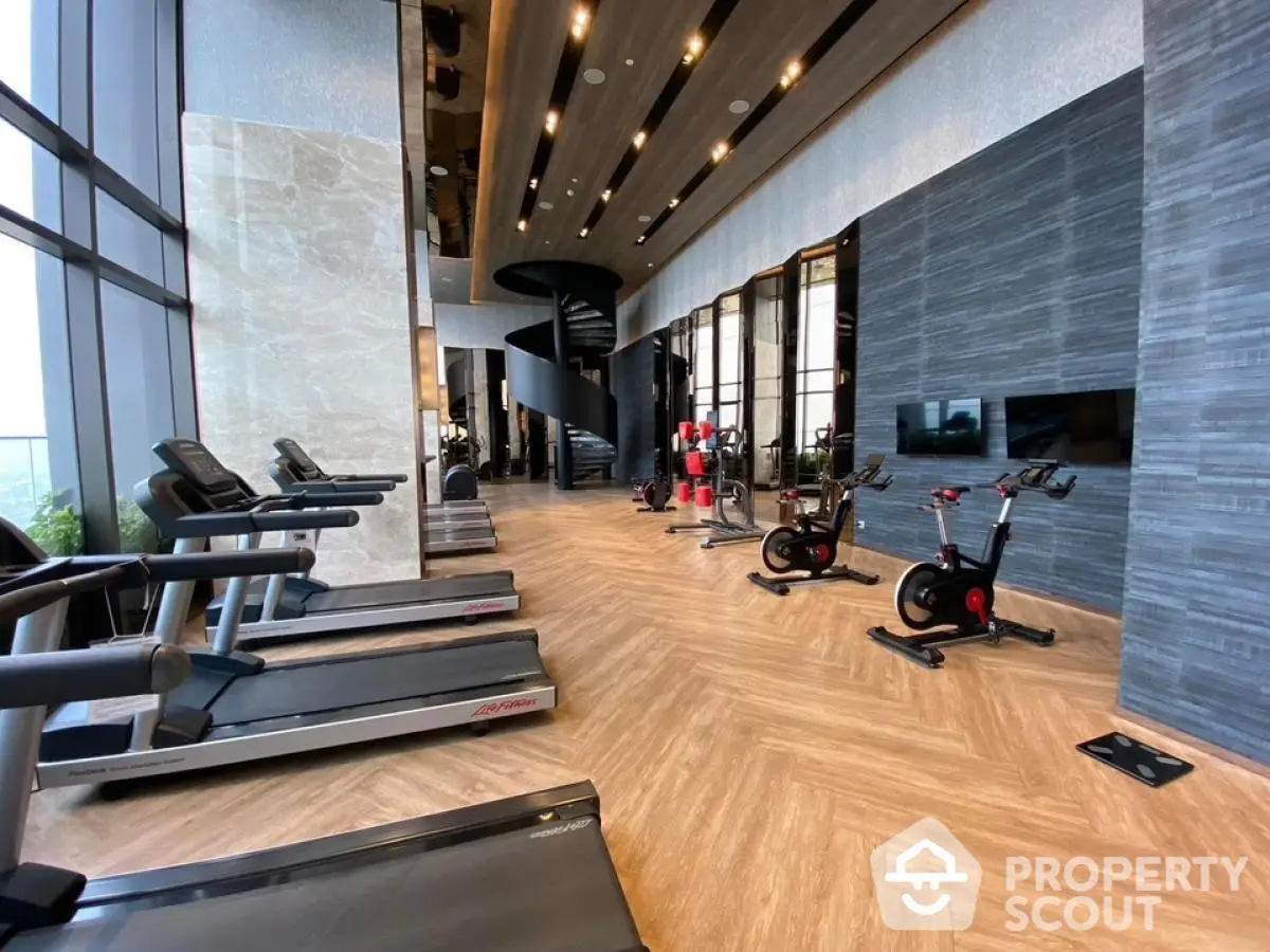 Luxurious high-rise gym with modern equipment and spiral staircase