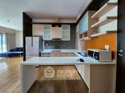 Modern kitchen with sleek design and open layout, featuring wooden flooring and contemporary appliances.