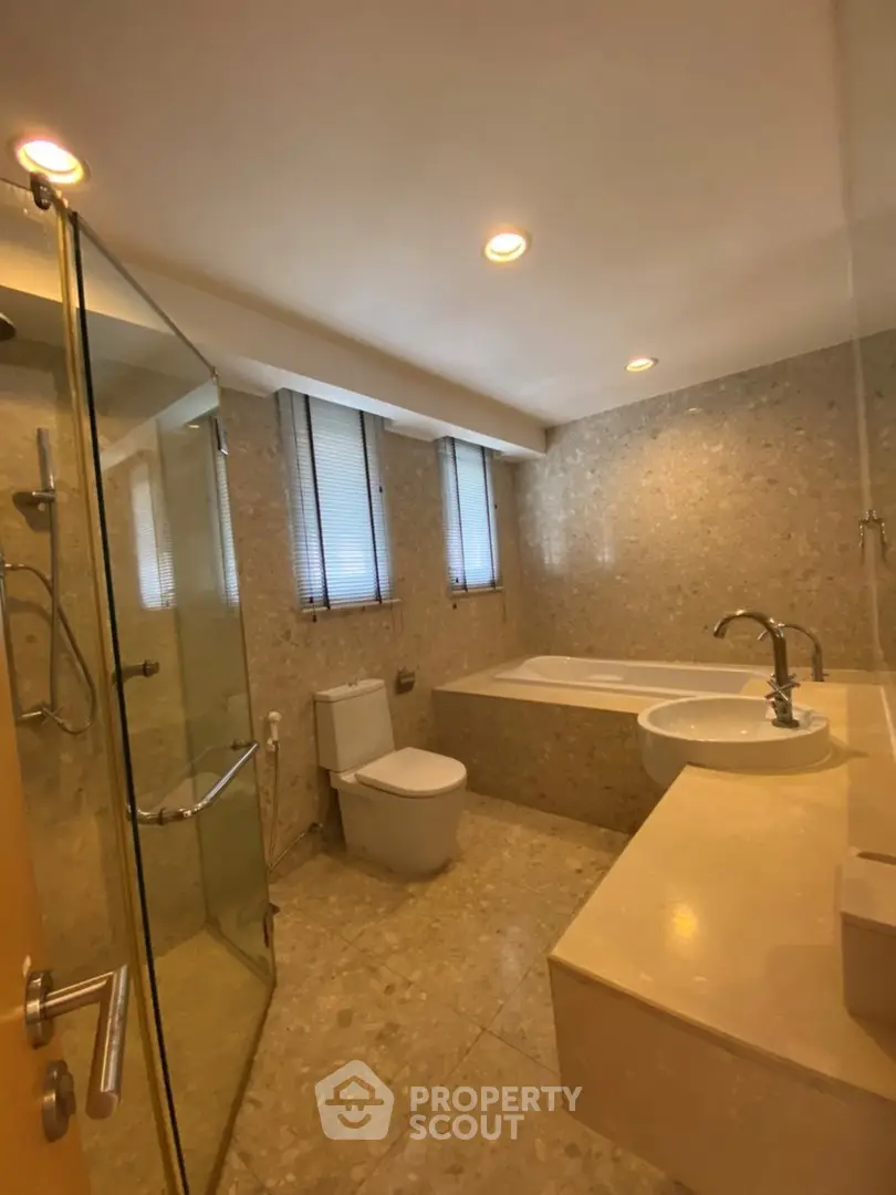 Luxurious bathroom with elegant stone finishes and modern fixtures in a high-end property.