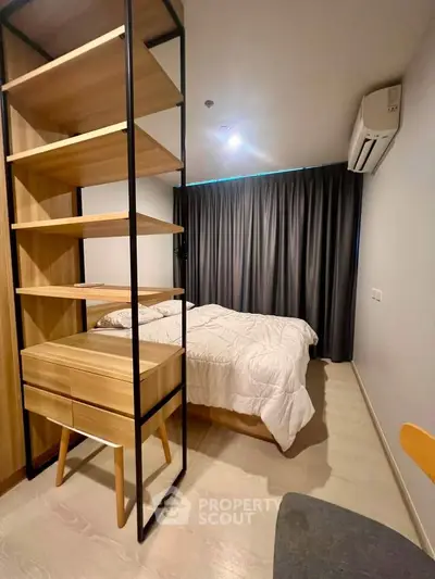 Modern bedroom with stylish shelving and cozy bedding in a well-lit apartment.
