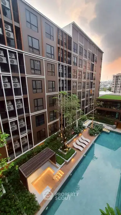 Luxurious condo with stunning pool and modern architecture at sunset.