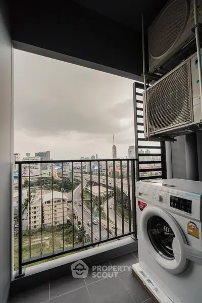 High-rise apartment balcony with city view and washing machine