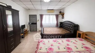 Spacious bedroom with two beds and ample natural light, ideal for comfort and relaxation.