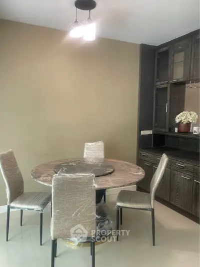 Modern dining area with round table and elegant chairs in a stylish interior.