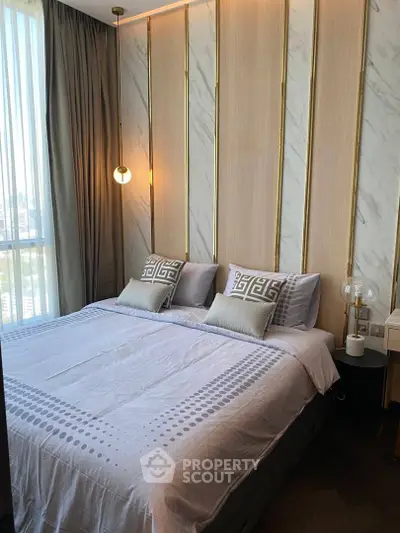 Luxurious bedroom with elegant decor and large window offering natural light.