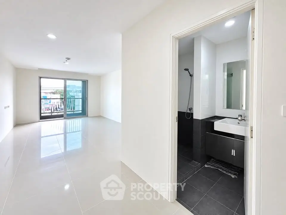 Spacious modern apartment with open living area and sleek bathroom design.