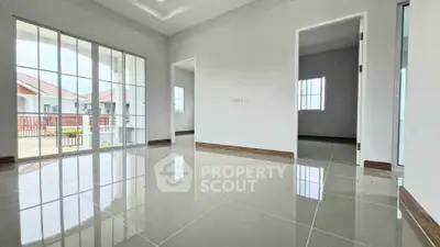 Spacious modern living room with glossy tiled floors and large windows offering natural light.