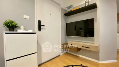 Modern apartment entrance with sleek wall-mounted TV and storage