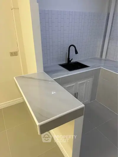 Modern kitchen with sleek countertops and stylish black faucet